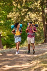 Couple With Backpacks On Vacation Hiking Through Forest Countryside Together