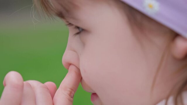 Young Caucasian Girl Picking Nose with Index Finger Front