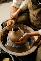 Pottery workshop a potter teaches a student to sculpt a jug from clay a couple is engaged in pottery