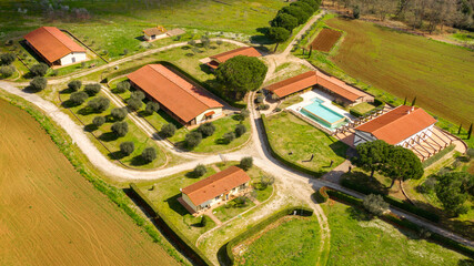 Fototapeta premium Aerial view of a large Italian farmhouse with a swimming pool. There is nobody in this period and the hotel is empty.