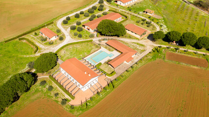 Aerial view of a large Italian farmhouse with a swimming pool. There is nobody in this period and the hotel is empty.