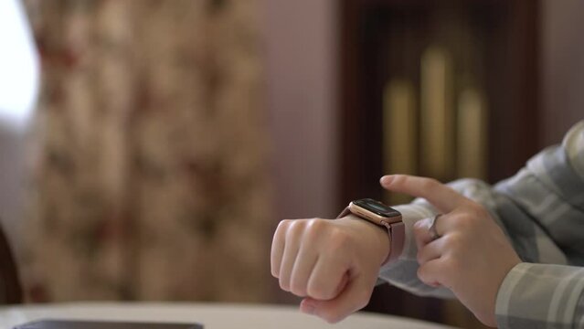 Woman using smartwatch touchscreen smart watch on her wrist