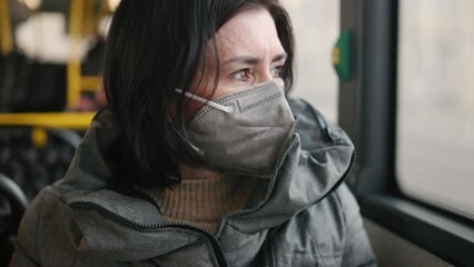 Woman rides a bus wearing protective face mask due quarantine. Pandemia covid-19 protective measures. - Powered by Adobe