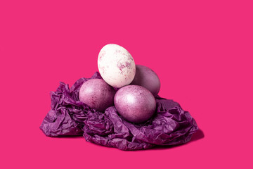 Colorful Easter eggs in a nest on a purple background