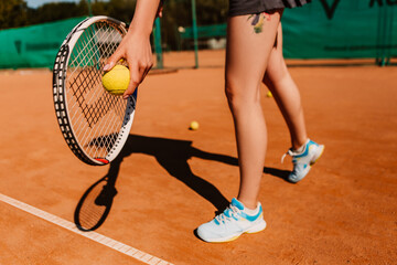 Fototapeta na wymiar Caucasian european woman hold yellow green ball, playing tennis match on clay court surface on weekend free time sunny day. Female player ready to serve. Professional sport concept 