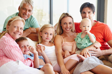 An abundance of love. Portrait of a loving multi-generational family sitting together on a sofa at home.