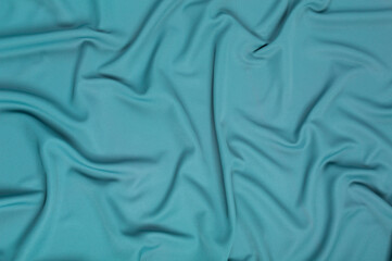 Texture, background, pattern. Texture of green silk fabric. Beautiful emerald green soft silk fabric.