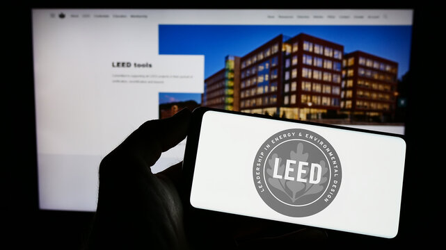 Stuttgart, Germany - 03-11-2023: Person Holding Cellphone With Logo Of US Green Building Certification LEED On Screen In Front Of Webpage. Focus On Phone Display.