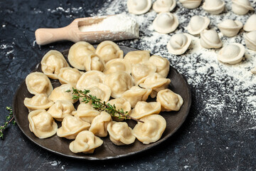 Traditional pelmeni, ravioli, dumplings with meat on black plate. Restaurant menu, dieting, cookbook recipe top view