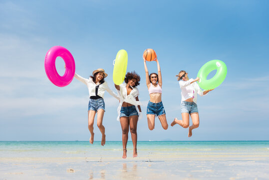 Group of teenager friends having fun with swim ring on the beach, Young girl enjoying with outdoor activity, Lifestyles on holiday concept.