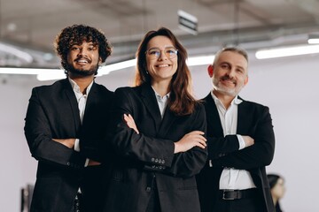 Diverse business team posing with smile. Confident businesspeople standing with arms crossed in office