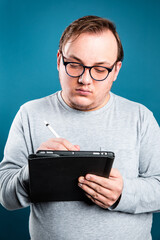 man with glasses and tablet writing