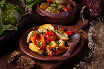 baked vegetables on a clay plate, dark photo, rustic style