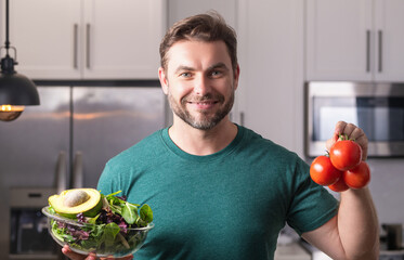 Portrait of attractive man preparing fresh natural weight loss meal at kitchen home indoors. Handsome cheerful man preparing meal in the kitchen. Healthy food, cooking concept. - Powered by Adobe
