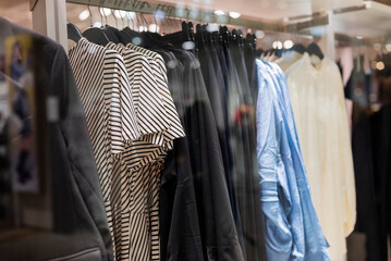 stylish blouses clothes hang on hangers in a store in a mall