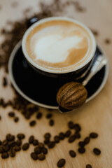A cup of latte coffee on the table stands in coffee beans close-up