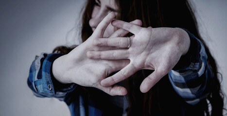 Stop gestute. Portrait of young woman looking in fear with her hand in front of face. Gestures,...