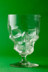 Taça de cristal em formato de caveira e fundo verde