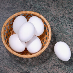 several fresh chicken eggs in a straw basket on a wooden background. Healthy eating concept. - 581558572