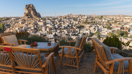 view from a street cafe with wooden chairs and tables on an ancient earthen city in Cappadocia, Turkey - 581558589