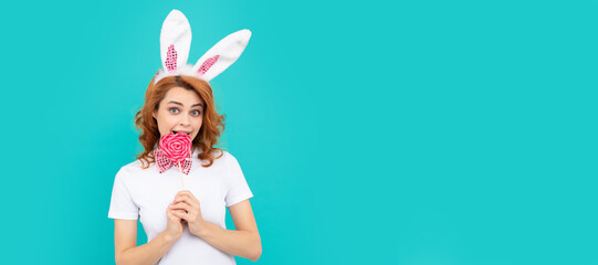 happy easter girl wear bunny ears hold yummy lollipop. Woman isolated face portrait, banner with...