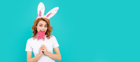 happy easter girl wear bunny ears hold yummy lollipop. Woman isolated face portrait, banner with mock up copyspace.