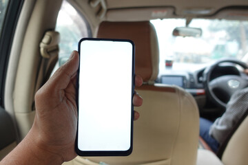 hand holding smart phone with empty screen in a car 