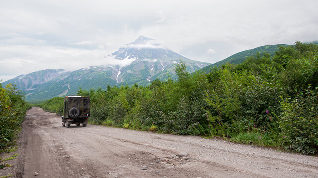 Off-road extreme expedition truck with passengers. Gravel road into Kamchatka.