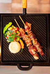 roast meat on wooden sticks with salad and flour. brazilian beef brochette