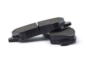 The brake pads lie one on top of the other, isolated on a white background. Side view