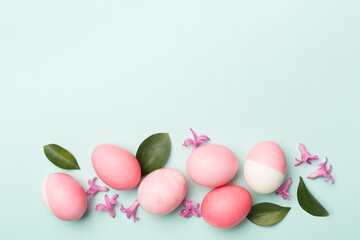 Pink Easter eggs with decor on color background, top view