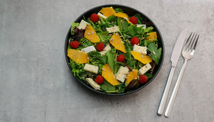 delicious green salad with oranges and brie cheese with copy space