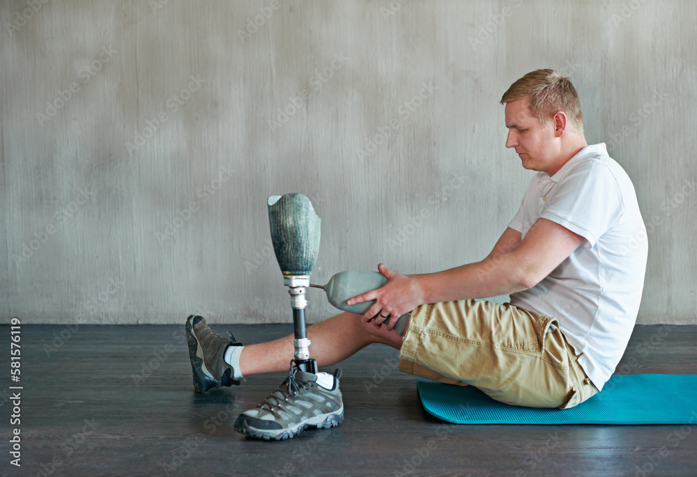 Sticker Working on his fitness. a young amputee working out on a gym floor.