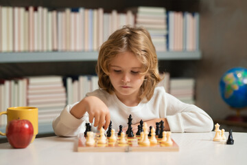 Little child chessman play chess game, checkmate. Kid playing chess in the room.