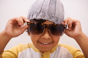 This kids got style. Portrait of a cute little boy wearing sunglasses and a beanie.