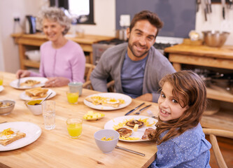 Obraz na płótnie Canvas Enjoying a yummy breakfast. a family eating breakfast around the kitchen table.