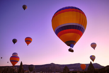 Low angle view of hot air balloons above spectacular volcanic landscape of Cappadocia. Goreme...