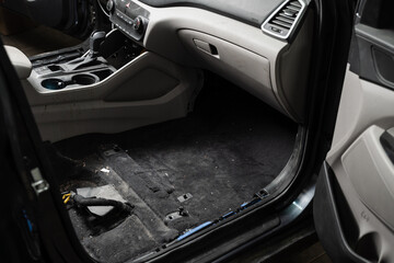 Dirty car floor with removed seats before vacuum cleaning in detailing service.