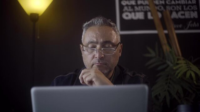 Male freelancer working remotely in his home office in front of his laptop.