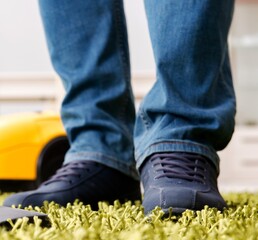 Man cleaning the floor carpet with a vacuum cleaner close up