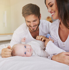 Mommy and daddy love me. a young couple and their baby daughter in the bedroom.