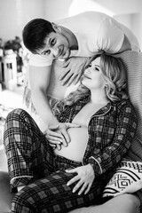 a pregnant woman and a man in pajamas in the home interior 