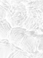 White water with ripples on the surface. Defocus blurred transparent white colored clear calm water surface texture with splashes and bubbles. Water waves with shining pattern texture background.