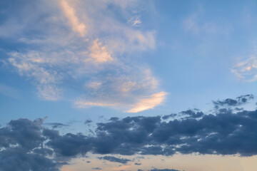 Summer evening sky in the picturesque clouds, lit by the rays of the setting sun.