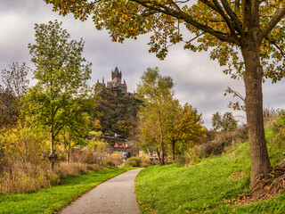 Naklejka premium Cochem castle, colourful autumn trees and pedestrian pathway in Cochem-Zell district, Germany