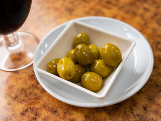 Fresh olives with pits nicely served in bowl on plate
