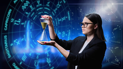 Young female with hourglass on background with astrological signs of zodiac