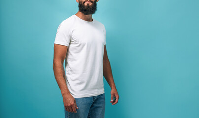 Portrait of handsome, young, stunning, perfect bearded guy wearing a white blank t-shirt stands...