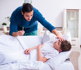 Obraz premium Young father caring for sick son