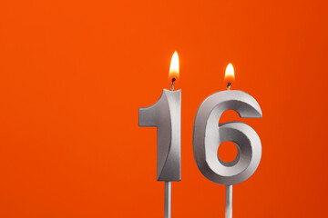 Number 16 - Silver Anniversary candle on orange background